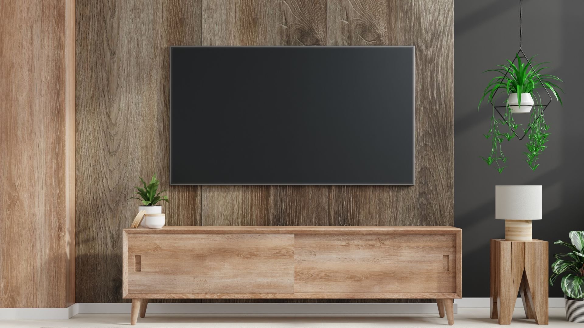 Modern living room with black TV, wooden console, and hanging plants