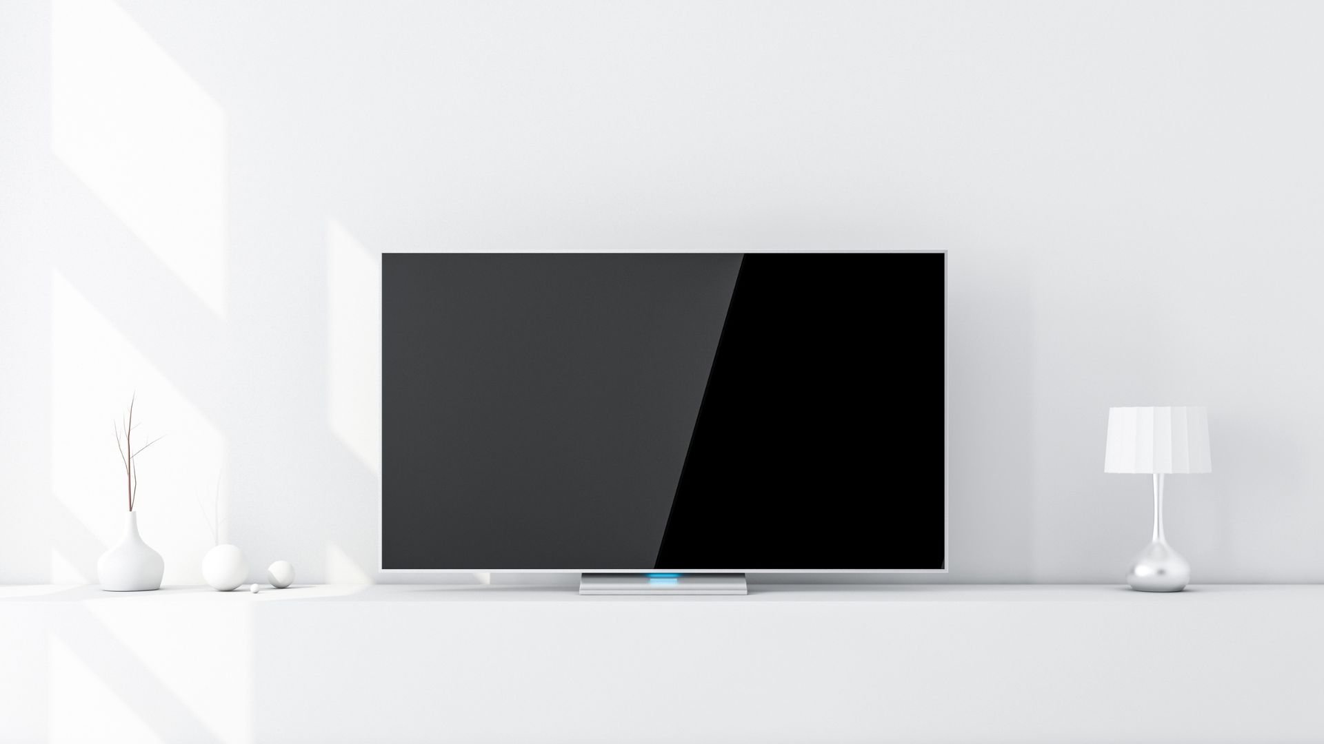 Modern black television on white surface with minimalist vases