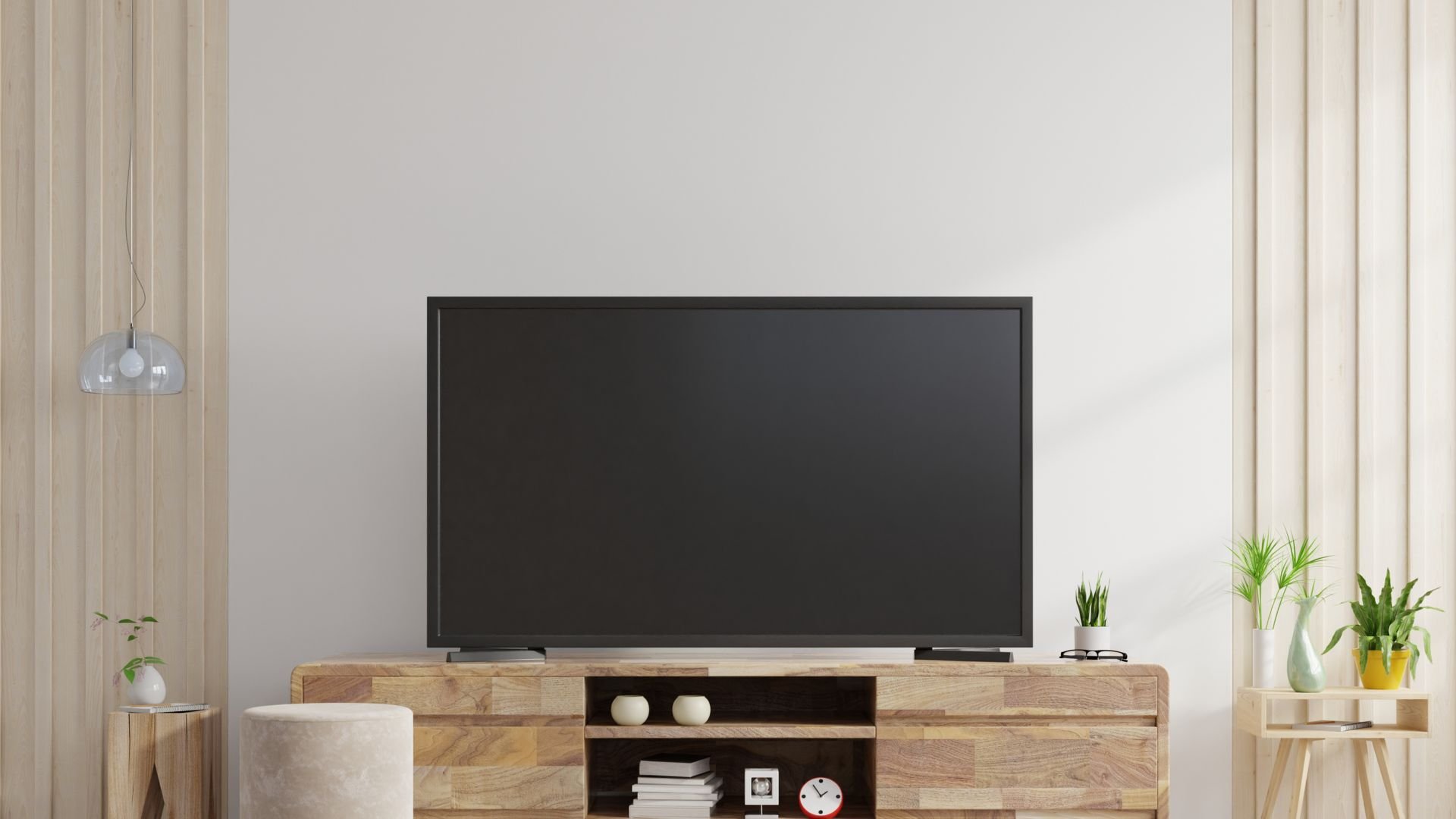Modern living room with black TV, wooden console, and potted plants
