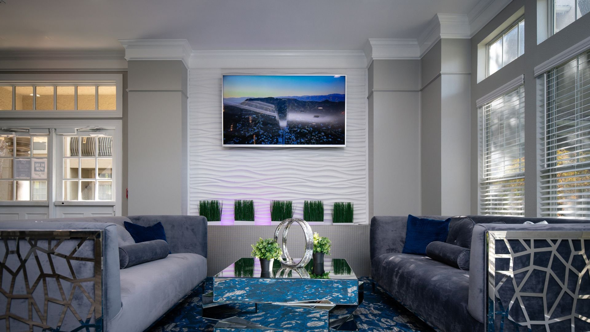 Modern living room with blue landscape art, gray sofas, and plants