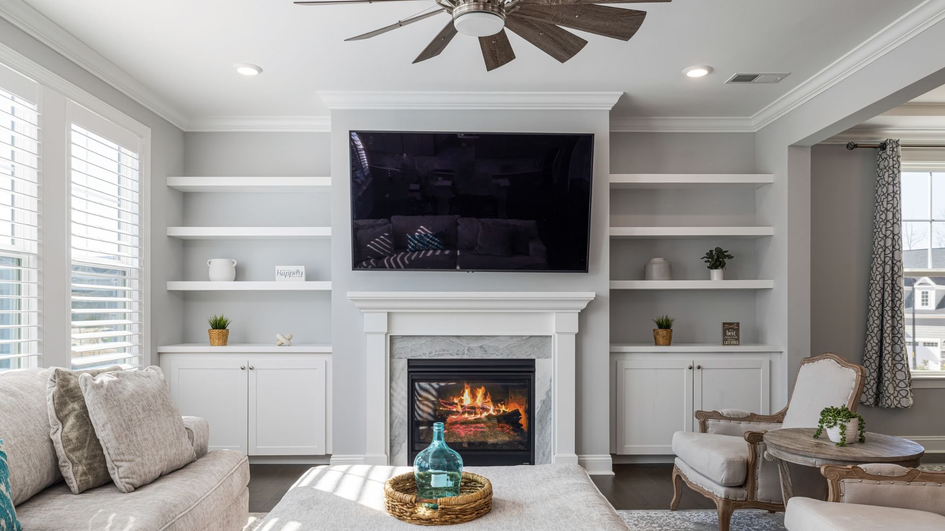 Cozy living room with white built-ins, fireplace, TV, and comfortable seating