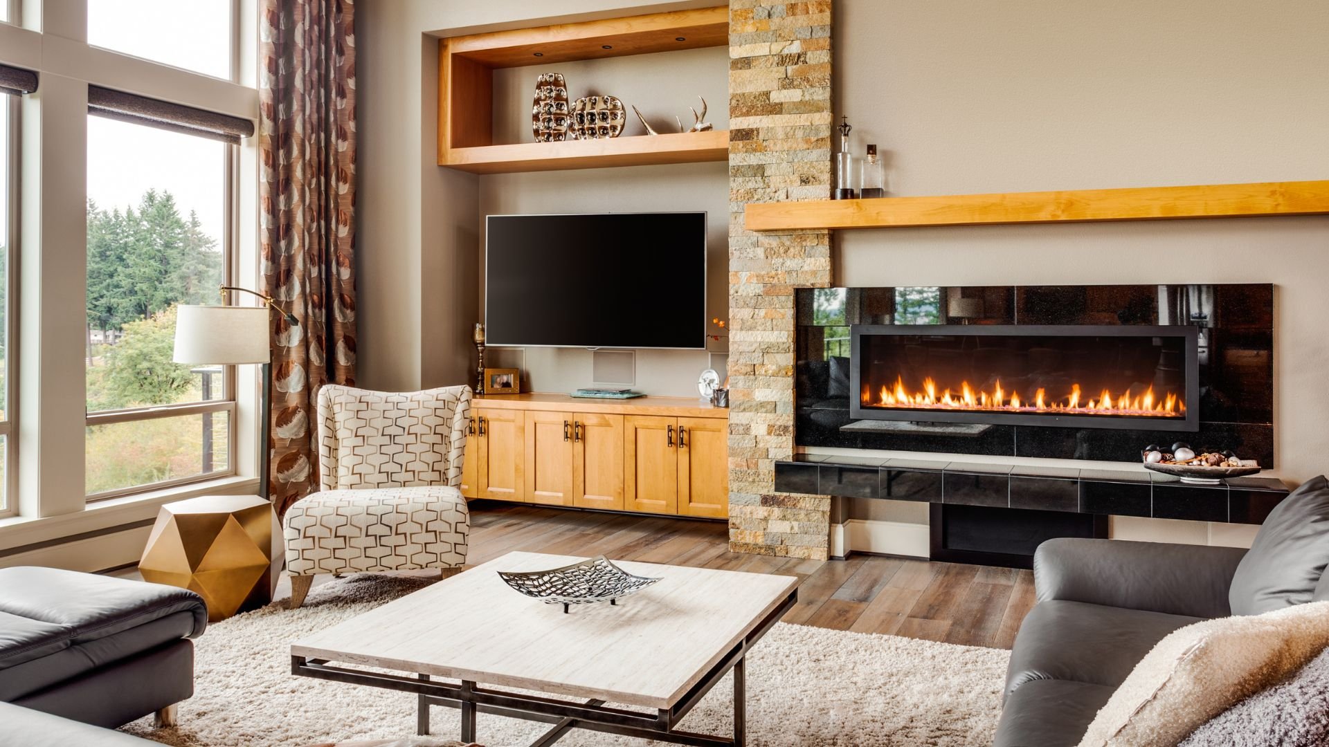 Modern living room with stone fireplace, TV, and cozy furniture